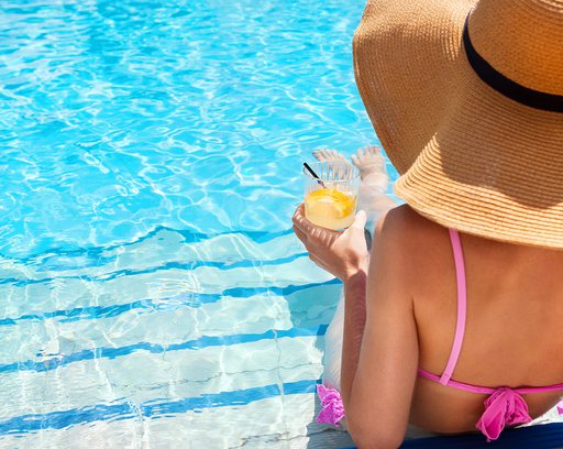 Woman enjoying cocktail in a swimming pool